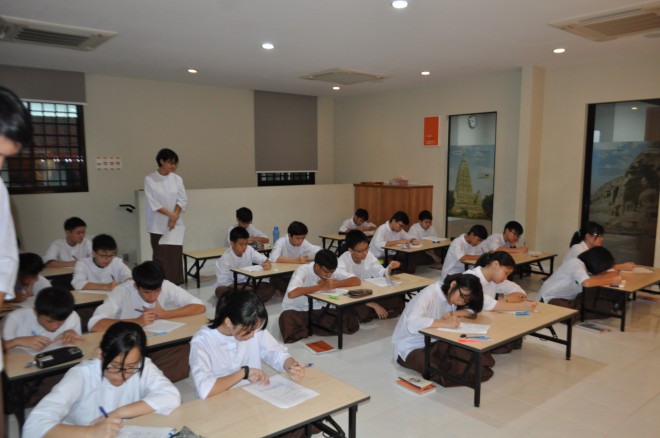 Dhamma School students at NEO Johor Bahru sitting for their year-end examination. They were tested on their basic understanding of Buddhism.