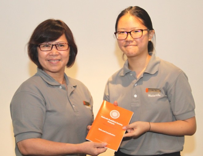 Sis. Evelyn welcomes and presents the Society’s 'Rules and Constitution' booklet to Sis. Jia Xin.