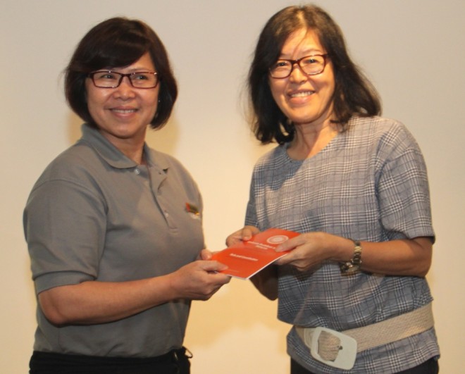 Sis. Evelyn welcomes and presents the Society’s 'Rules and Constitution' booklet to Sis. Poh Peng.