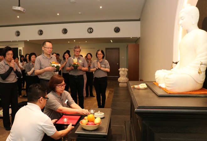 President leading the offerings to Buddha, Dhamma and Sangha.