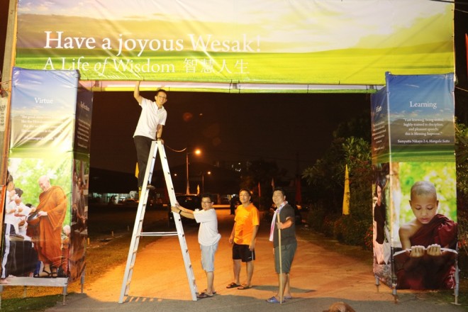 Always full of cheer, volunteers worked late into night to prepare the venue for Wesak Day.
