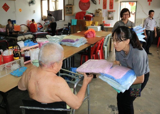 Nalandians offering towels to the senior citizens at Tong Sim.