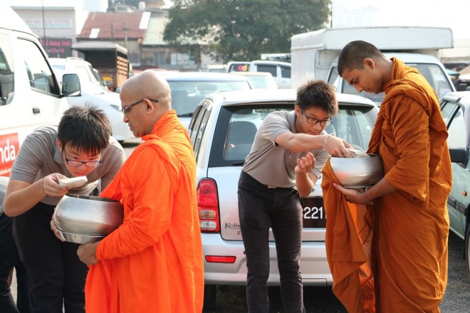 Nalanda Dhamma School students offering help as well as alms. 