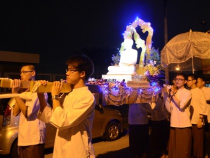 Carrying the Sedan symbolizes upholding the Buddha-Dhamma with faith and devotion.