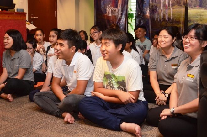 Dhamma School facilitators and students joyfully listening to the talk.