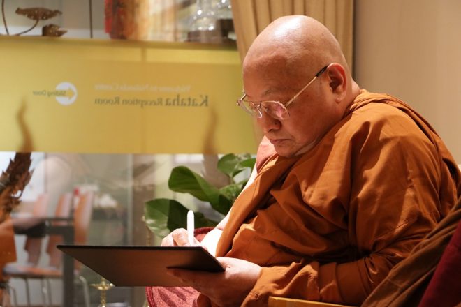 Sayadaw penning an autograph after his visit.
